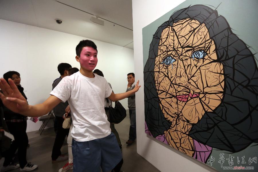 4月8日，南京艺术学院环境编舞专业的学生在“大脸画——岳敏君新作展”上为观众表演“身体的笑容——红脸人的故事”现代舞。