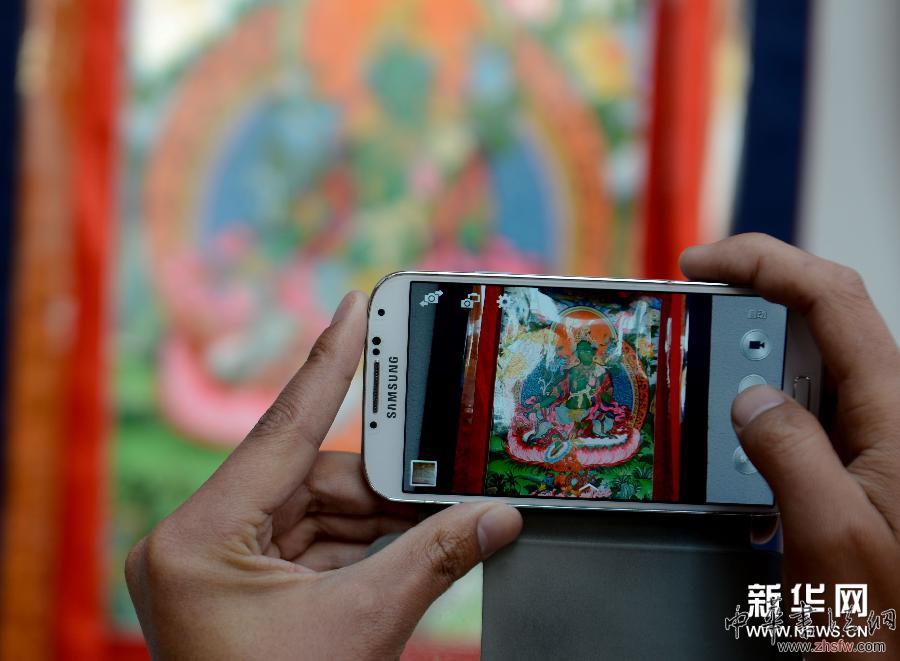 4月10日，一名参观者在展览现场拍摄展出作品。