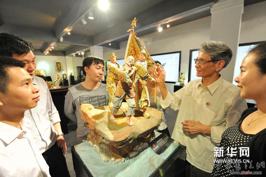 4月13日，蔡水况（右二）向蔡氏漆线雕技艺传习所学生介绍他父亲蔡文沛的漆线雕作品《郑成功收复台湾》。