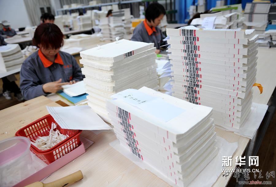 4月16日，装订车间工人在为《四库全书》书页“齐栏”。