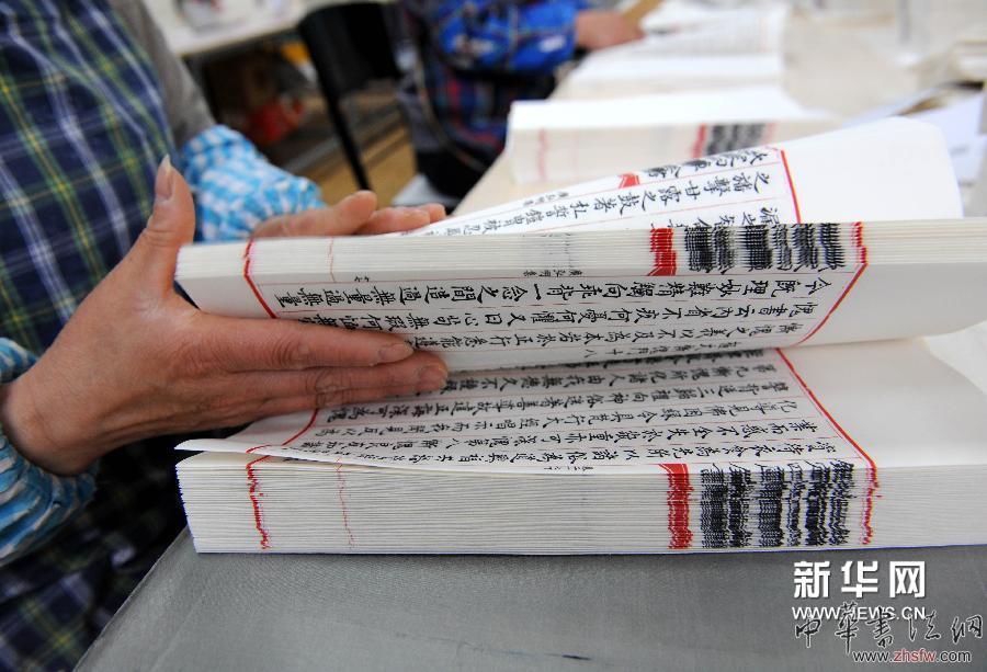 4月17日，工人为即将装订的《四库全书》书页核对页码。