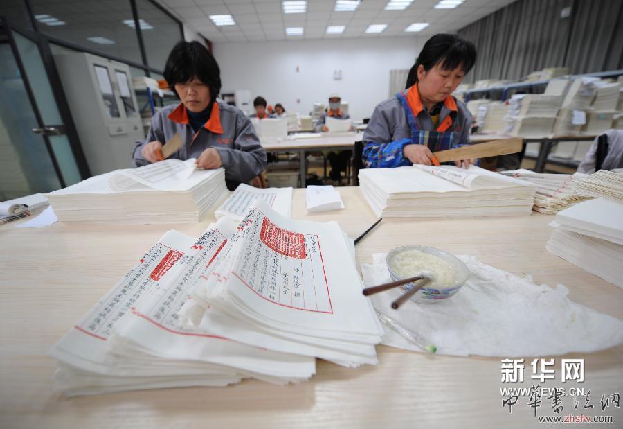 4月16日，装订车间工人在对《四库全书》书页进行“折页”操作。