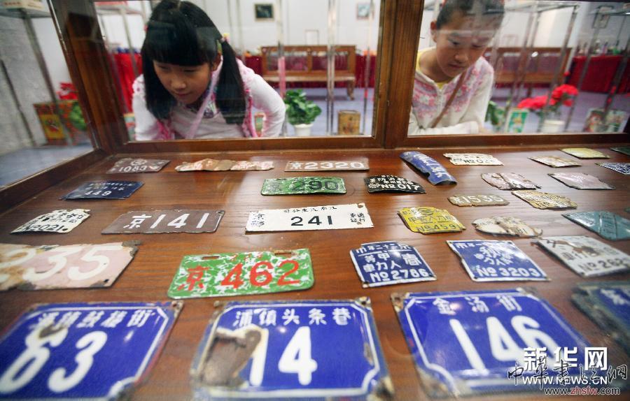 5月10日，两名女孩在展览上观看老式门牌。