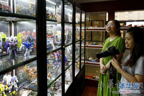 7月2日,在怀旧玩具展上,两位观众在摆满变形金刚玩具的展柜前参观。新华社记者 方喆 摄