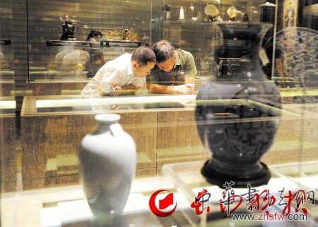 　长沙市文物商店去年重新开业，闻信而来的藏家在品鉴古玩。除了权威机构出具的文物鉴定书，藏家提高自身水平也是防止上当受骗的关键。 长沙晚报记者 王志伟 摄