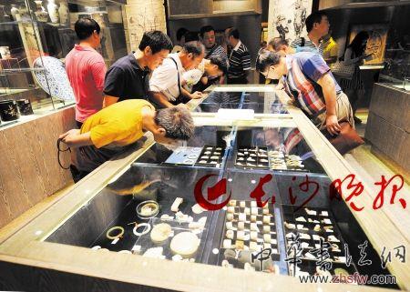 长沙市文物商店内，众多古玩爱好者在品鉴琳琅满目的文物。 　　长沙晚报记者 王志伟摄